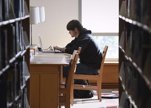 {A male student studies in a library}